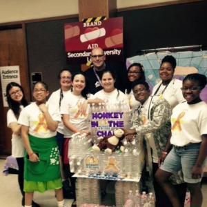 Ted Grossnickle (back center), Affiliate Director for Destination Imagination (DI) Michigan, poses with a DI Michigan team at a DI tournament. 